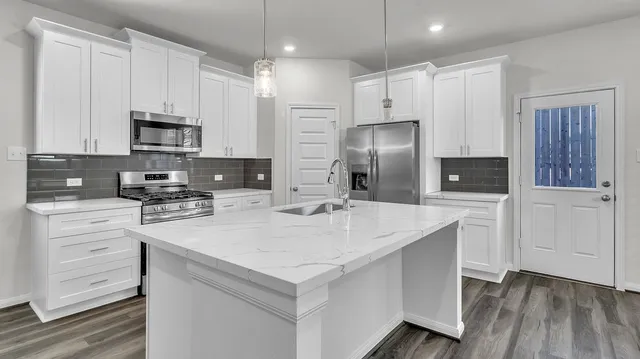 a kitchen with a refrigerator and a stove top oven
