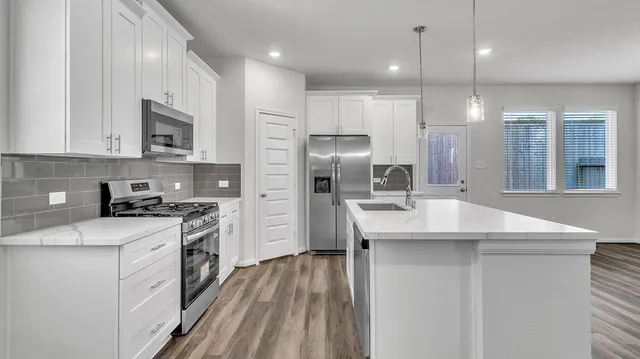a kitchen with stainless steel appliances granite countertop a sink stove and refrigerator