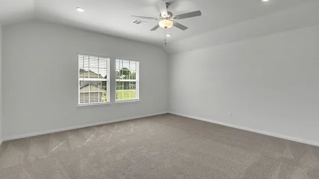 an empty room with a window and a fan