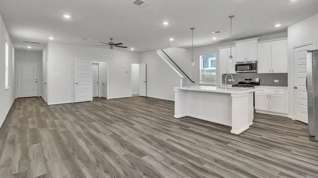 a kitchen with stainless steel appliances granite countertop a stove and a refrigerator