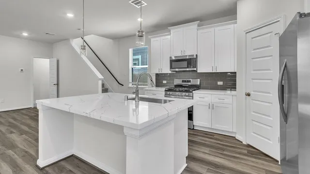 a kitchen with white cabinets and sink