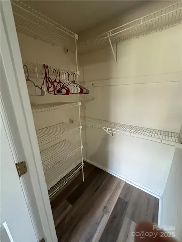 a view of empty room with wooden floor and entryway