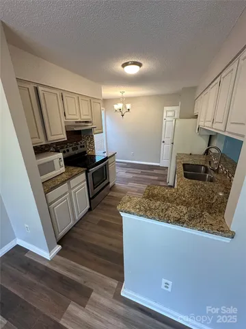 a kitchen with stainless steel appliances granite countertop a sink stove and microwave