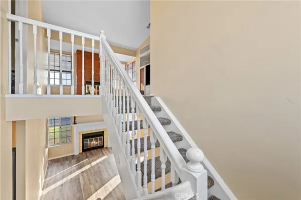 a view of staircase with lots of frames on wall and a window