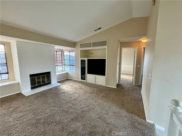 an empty room with a fireplace and window