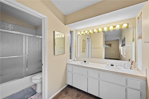 a spacious bathroom with a double vanity sink toilet and shower