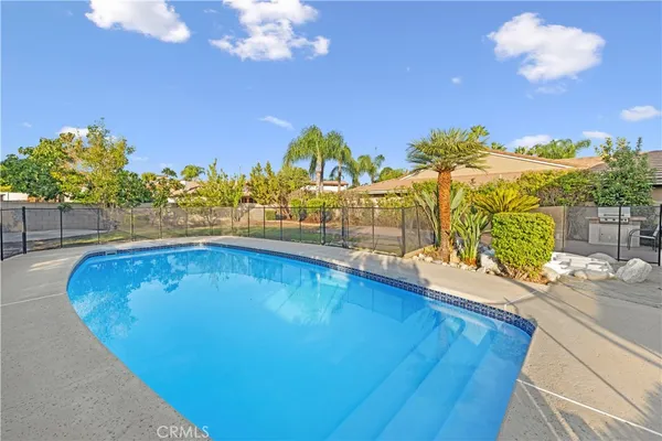 a view of a swimming pool with an outdoor seating and a floor to ceiling window