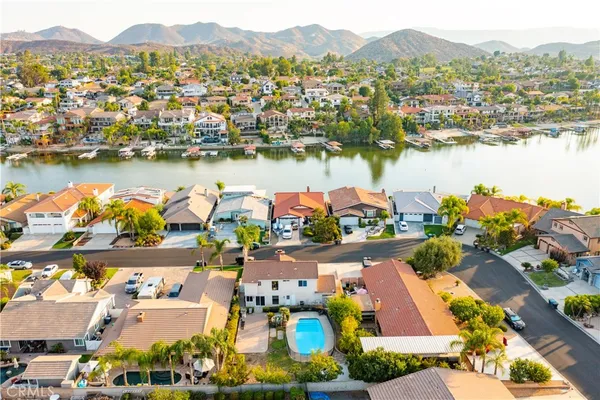 an aerial view of residential houses with outdoor space and lake view