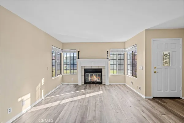 a view of an empty room with a fireplace and a window