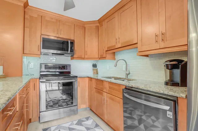 a kitchen with stainless steel appliances granite countertop a sink stove and microwave