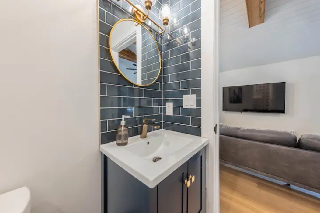2319 Santa Rita Street Austin, TX 78702 - Photo 15 of 26 Bathroom with vanity, decorative backsplash, tile walls, and light wood-style floors