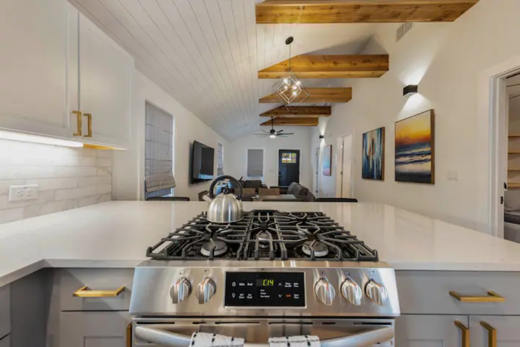2319 Santa Rita Street Austin, TX 78702 - Photo 25 of 26 Kitchen with gas range, open floor plan, wooden ceiling, vaulted ceiling with beams, and backsplash