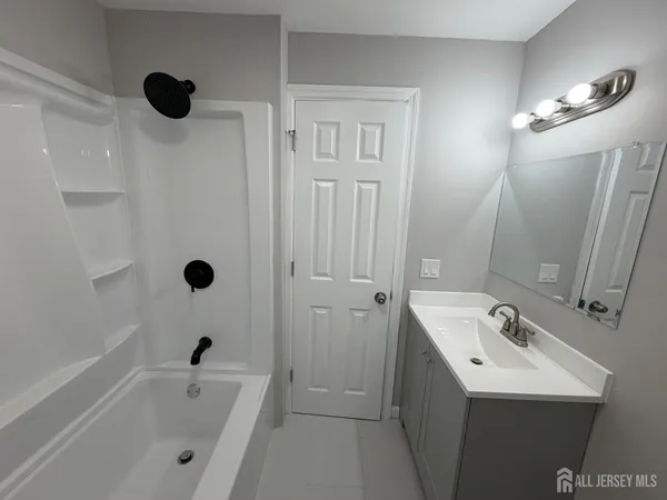 a bathroom with a tub sink and mirror