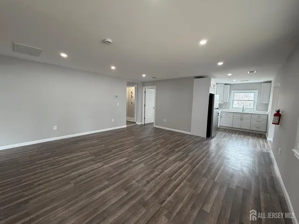 a view of a big room with wooden floor and windows