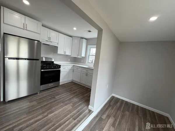 a kitchen with a refrigerator and a stove top oven