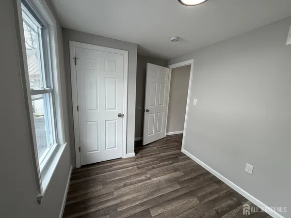 a view of a hallway with wooden floor and windows