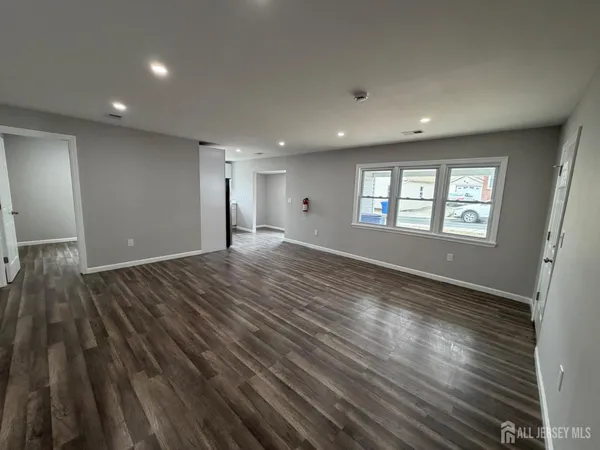 a view of empty room with window and wooden floor