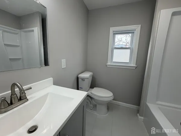 a bathroom with a sink a toilet and a mirror