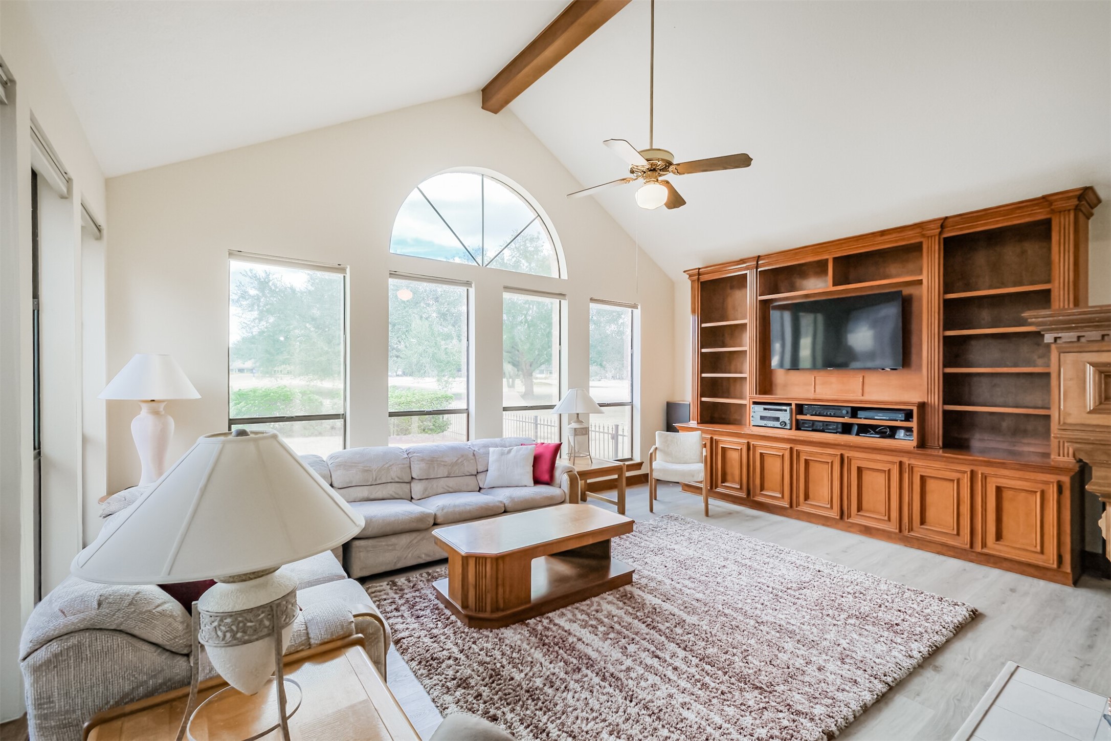 32726 Weybridge Street Fulshear, TX 77441 - Photo 25 of 50 a living room with furniture floor to ceiling window hardwood floor and a flat screen tv