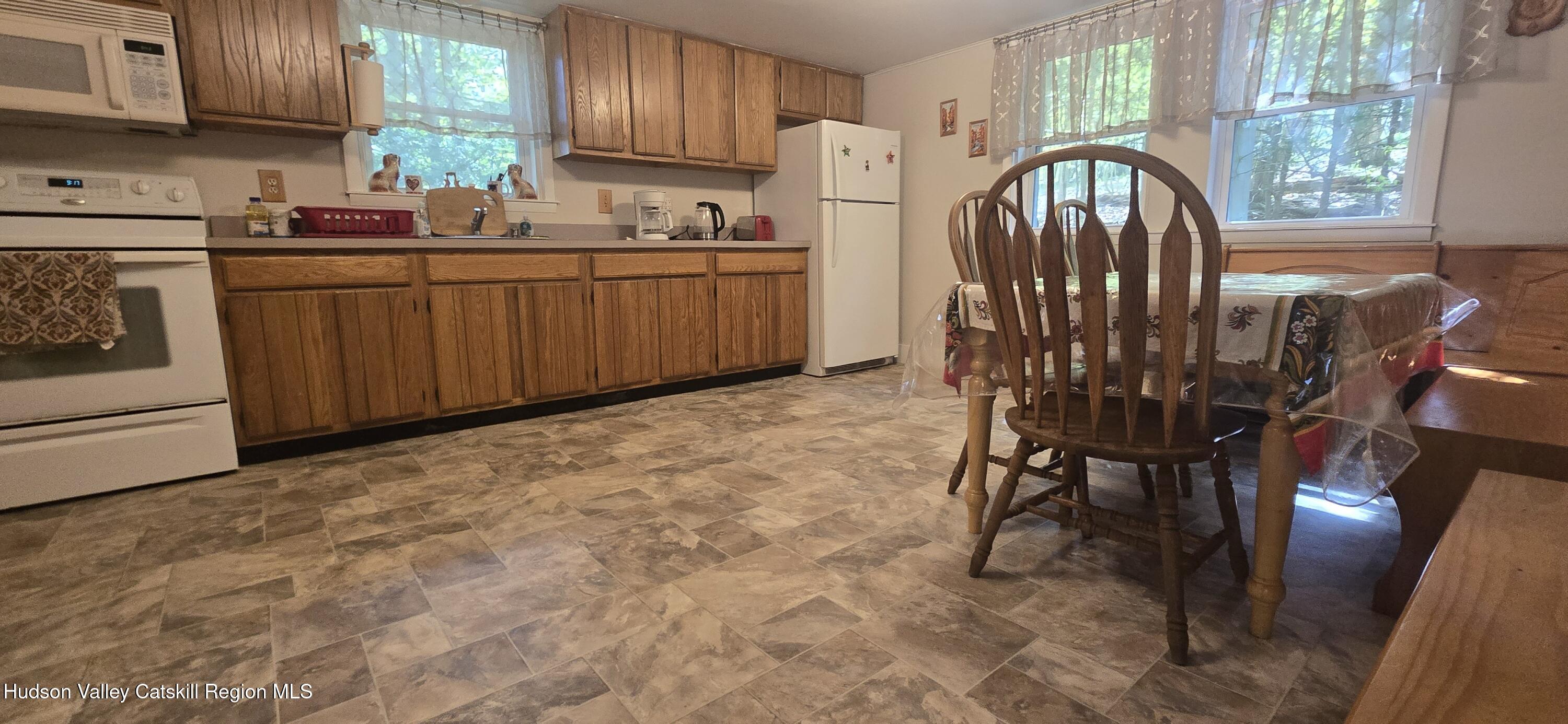 51 Enchanted Valley Road Cornwallville, NY 12418 - Photo 9 of 21 a kitchen with stainless steel appliances a table chairs in it and wooden floors
