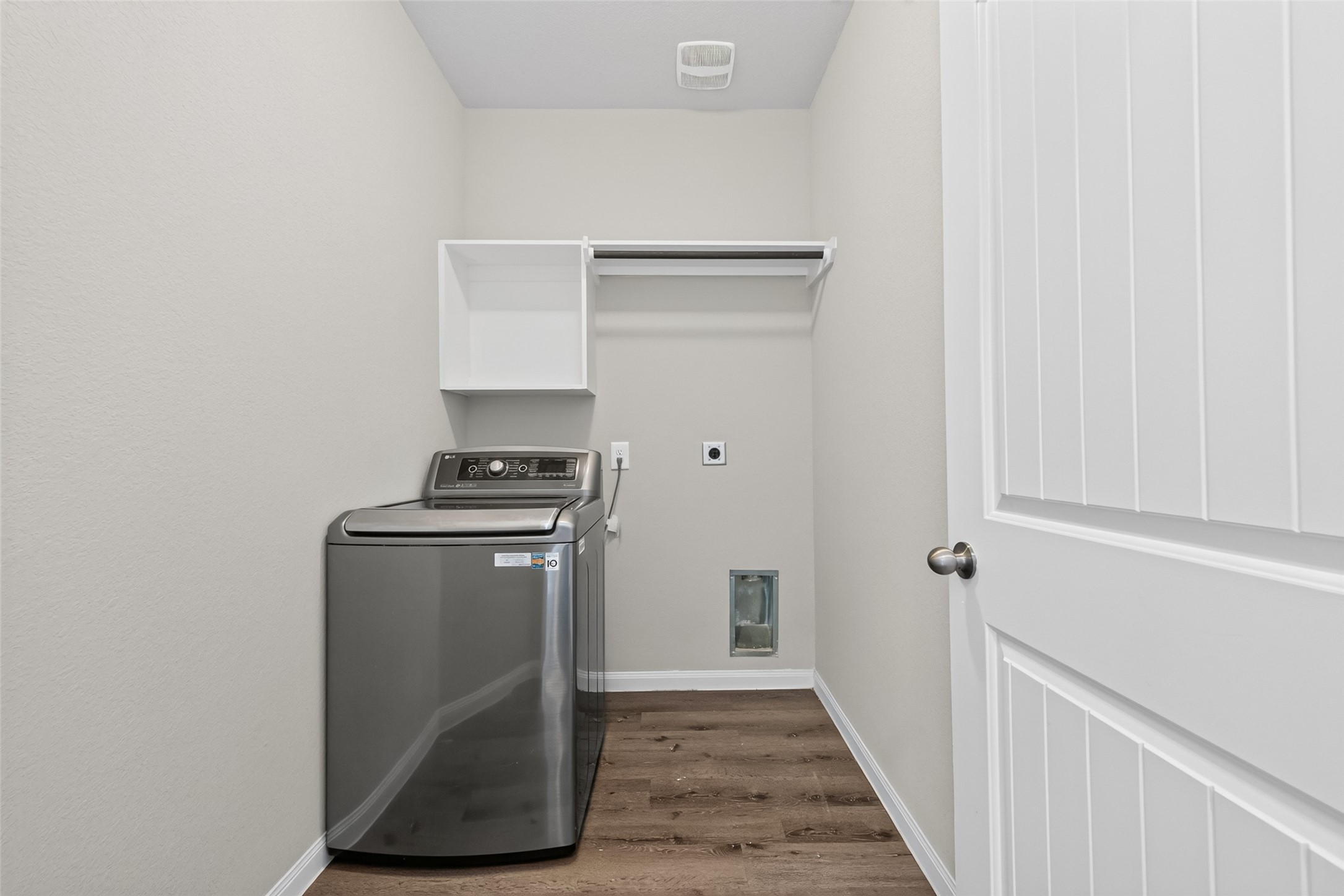 2526 Sturgeon Way Conroe, TX 77384 - Photo 16 of 49 This photo shows a compact laundry room featuring a modern washing machine & dryer , an open shelf, and a hanging rod.