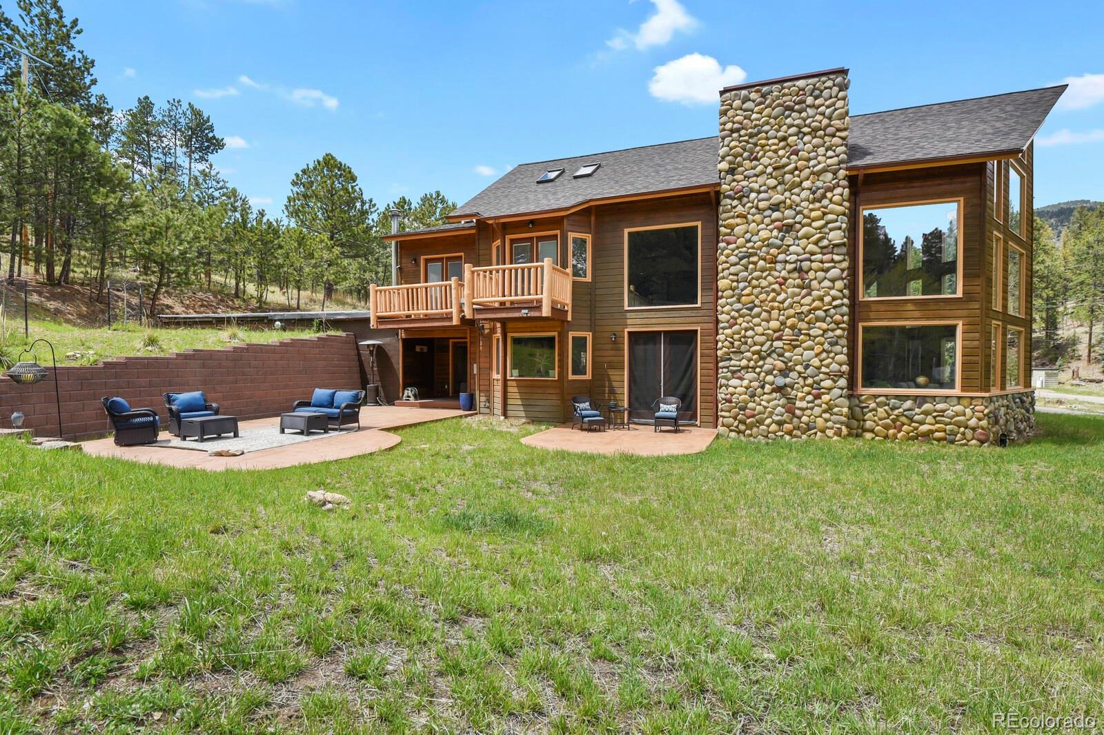 417 Witter Gulch Road Evergreen, CO 80439 - Photo 46 of 50 a view of a house with backyard sitting area and garden