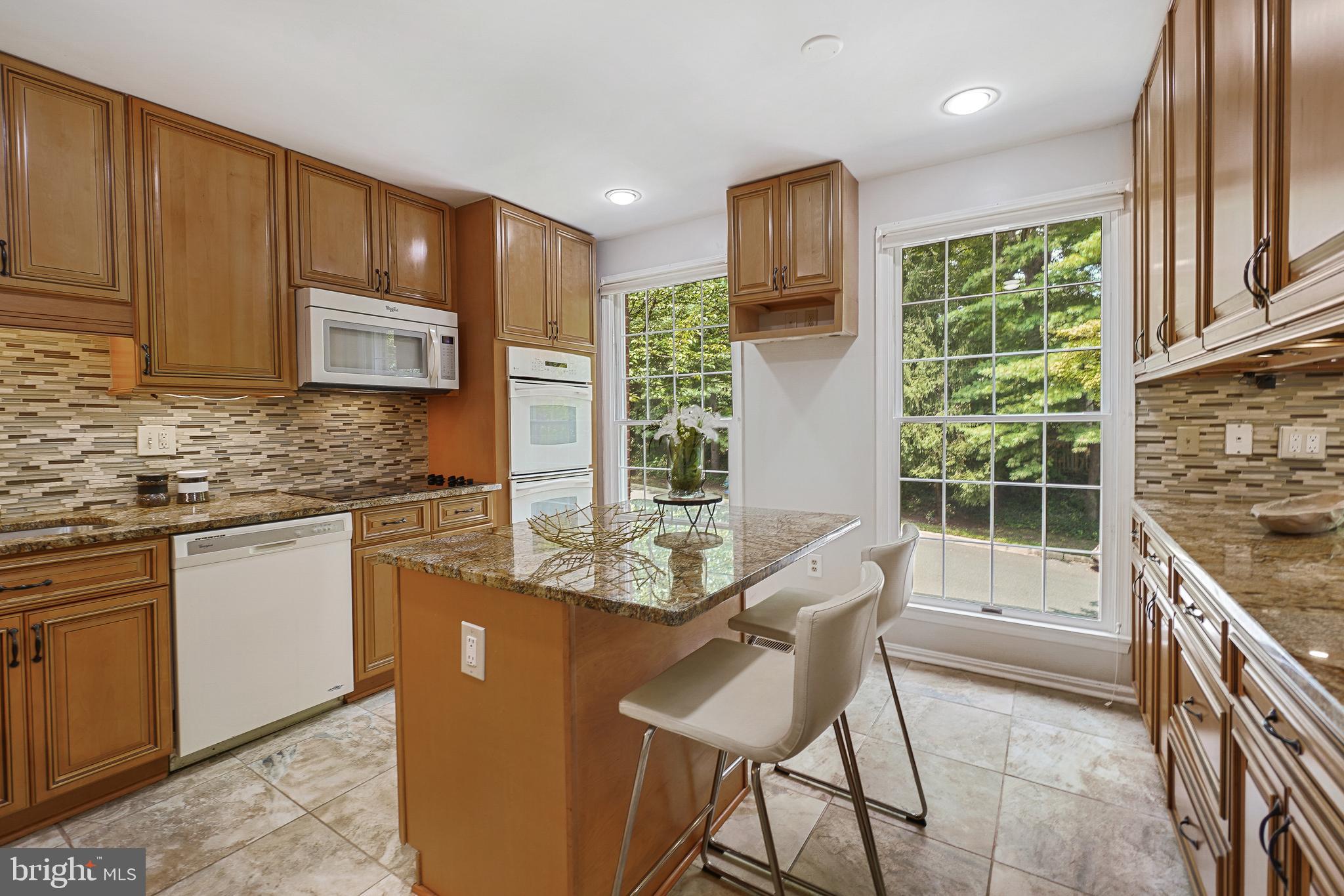 2757 Unicorn Lane Northwest Washington, DC 20015 - Photo 20 of 43 a kitchen with granite countertop a stove a sink a window and stainless steel appliances