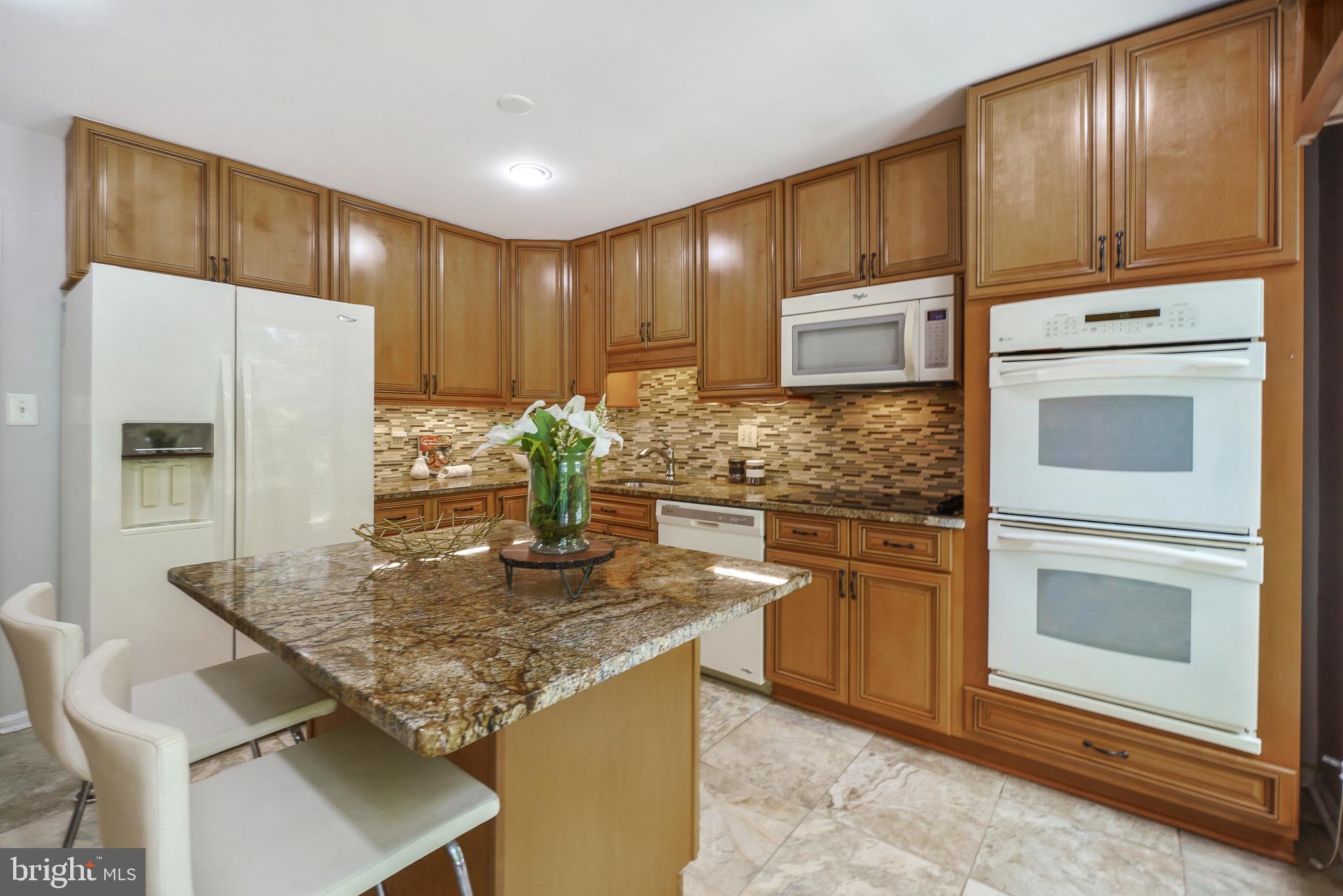 2757 Unicorn Lane Northwest Washington, DC 20015 - Photo 21 of 43 a kitchen with stainless steel appliances granite countertop wooden cabinets refrigerator and stove