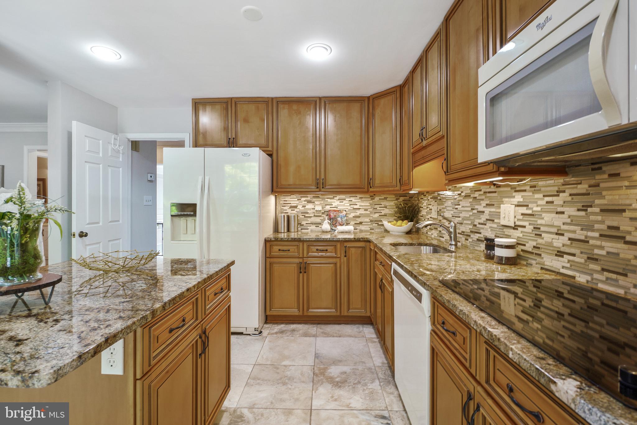 2757 Unicorn Lane Northwest Washington, DC 20015 - Photo 22 of 43 a kitchen with stainless steel appliances granite countertop a stove a refrigerator and a wooden cabinets