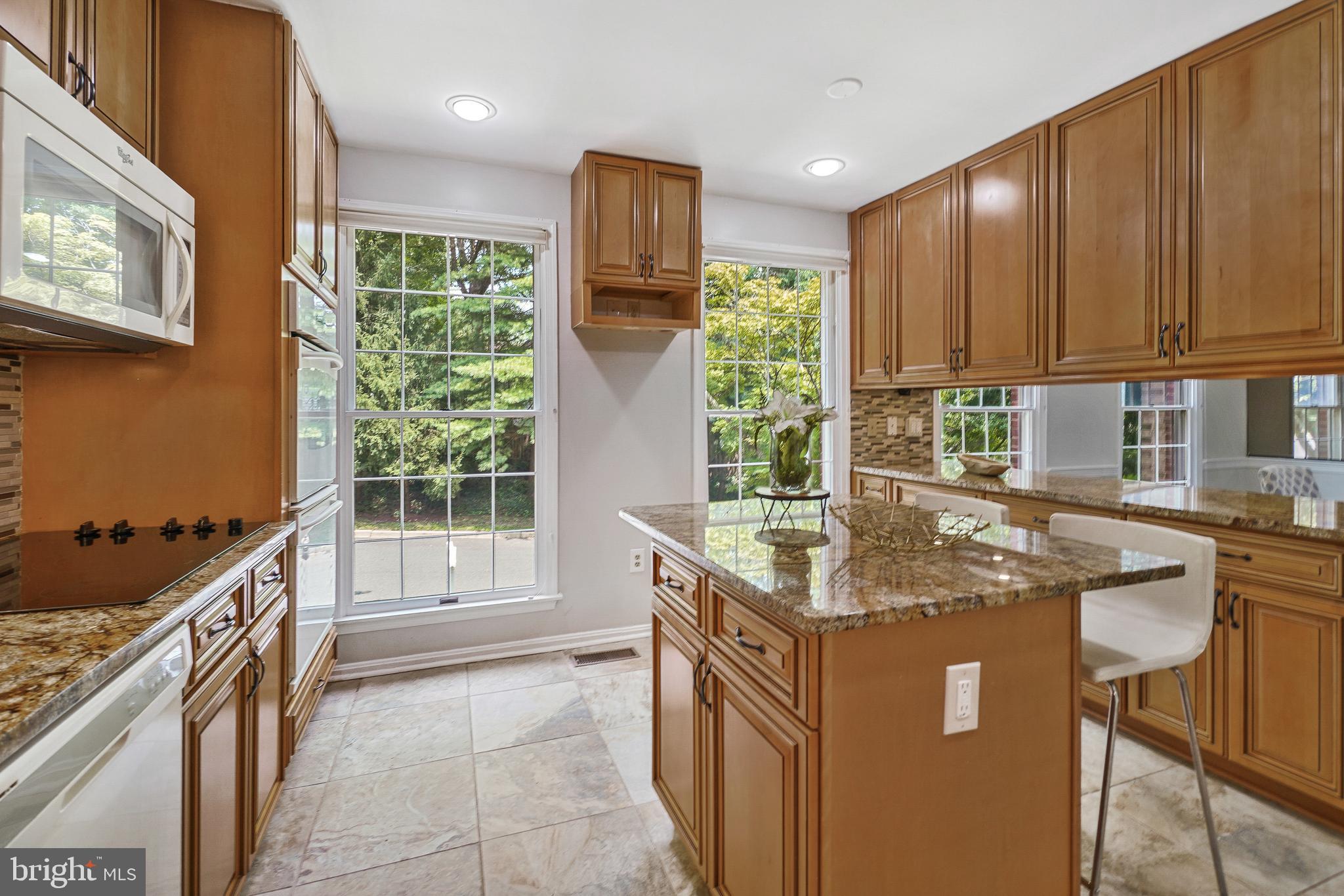 2757 Unicorn Lane Northwest Washington, DC 20015 - Photo 24 of 43 a kitchen with kitchen island granite countertop a stove a sink and a microwave