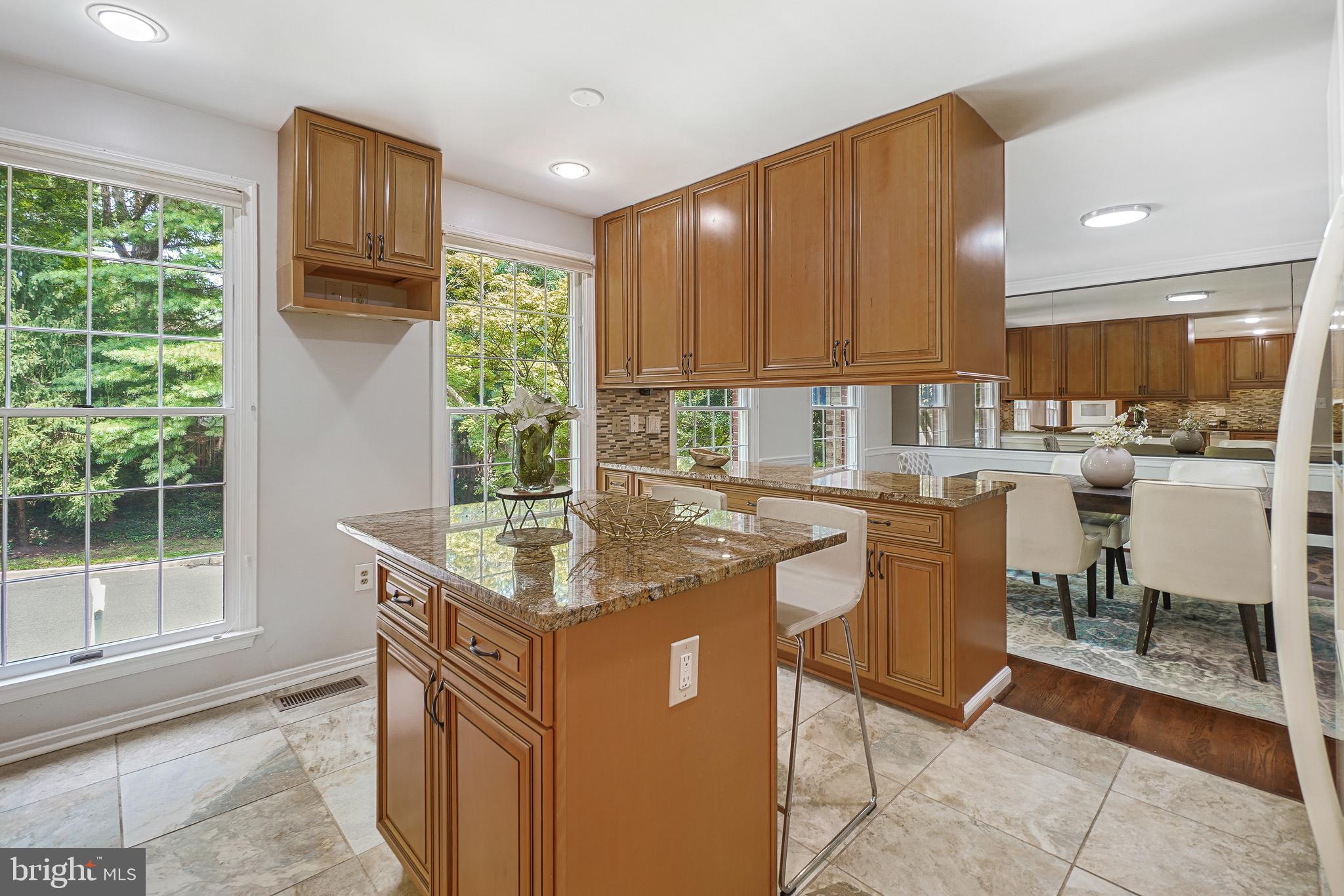 2757 Unicorn Lane Northwest Washington, DC 20015 - Photo 25 of 43 a kitchen with granite countertop a stove a sink a dining table and chairs