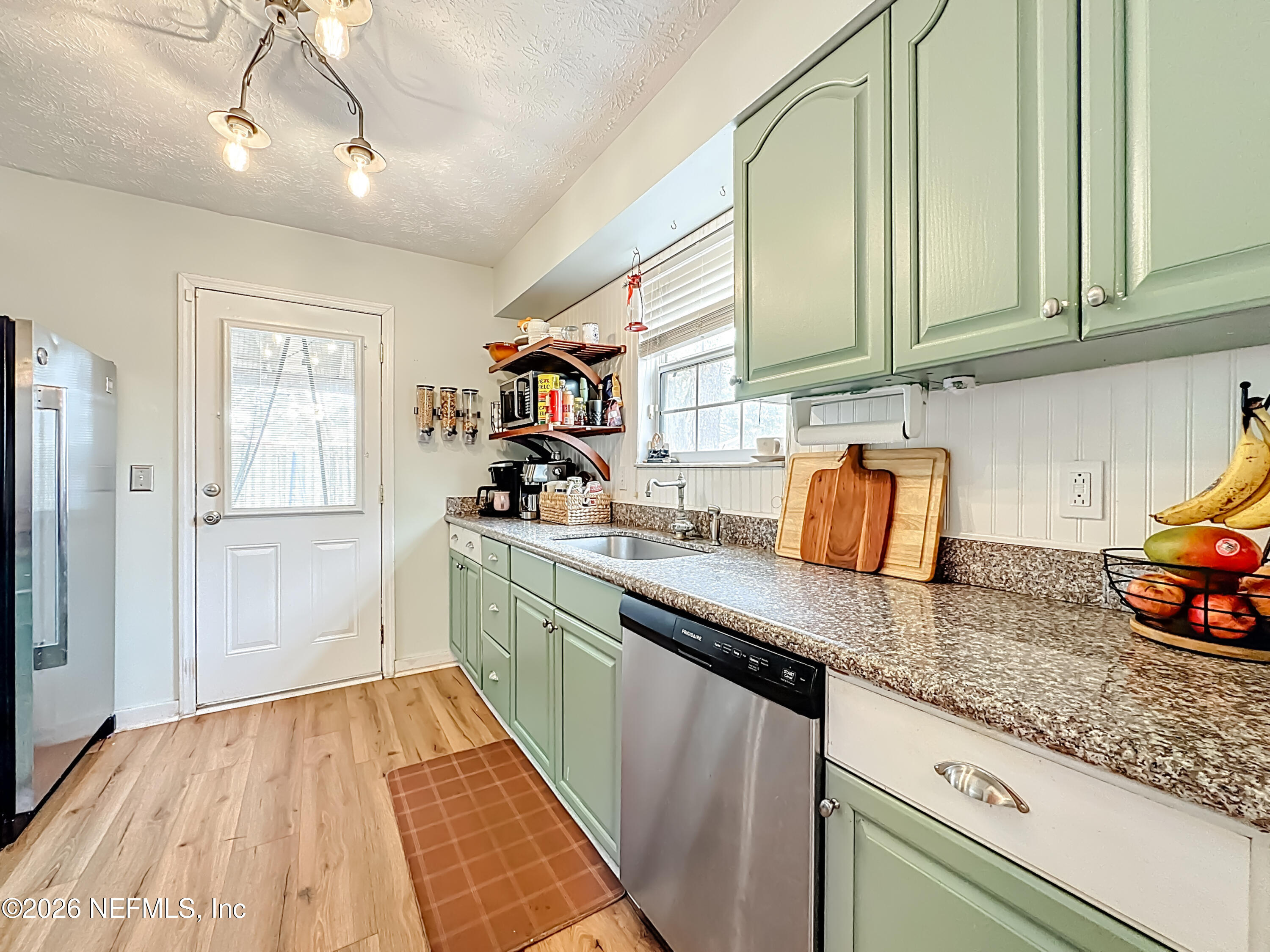 8302 Cassie Road Jacksonville, FL 32221 - Photo 20 of 48 a kitchen with stainless steel appliances granite countertop a sink and dishwasher with wooden floor