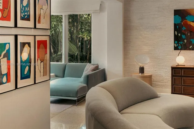 a living room with furniture a flat screen tv and kitchen view