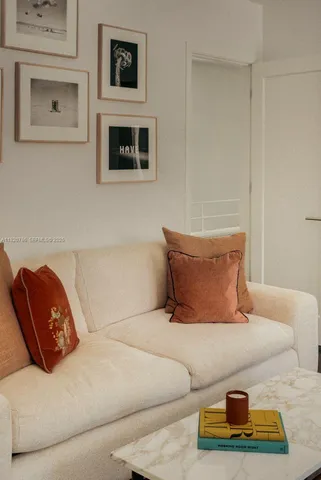 a living room with a couch dresser and a window