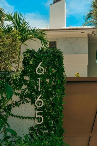 a front view of a house with swimming pool table and chairs