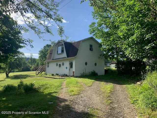 a front view of a house with a garden and trees
