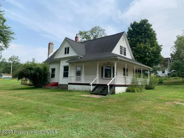 a view of a house with a yard and sitting area