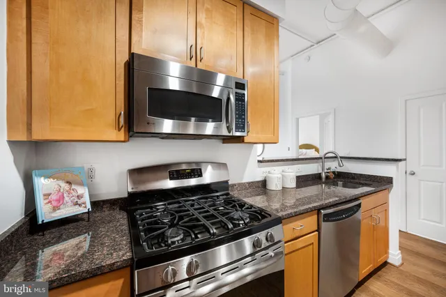 a kitchen with stainless steel appliances granite countertop a stove and a microwave