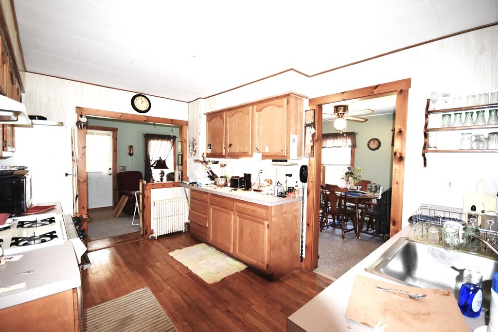 273 Snipatuit Road Rochester, MA 02770 - Photo 6 of 7 a kitchen with stainless steel appliances kitchen island granite countertop a refrigerator a sink dishwasher a dining table and chairs with wooden floor