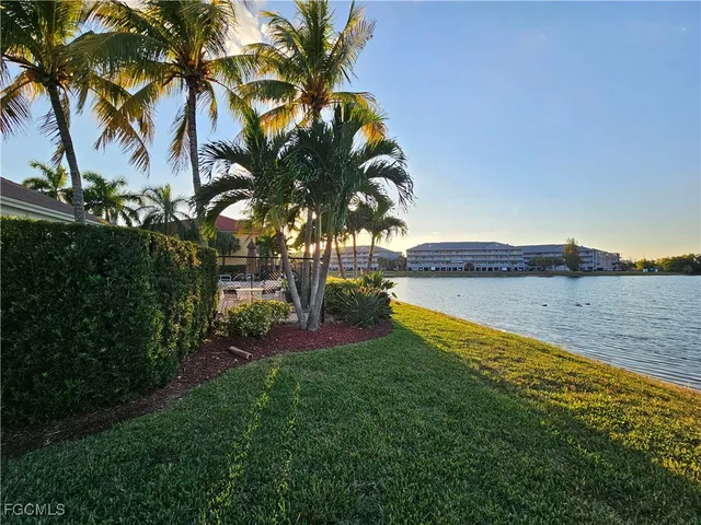 a view of a house with a yard and palm trees