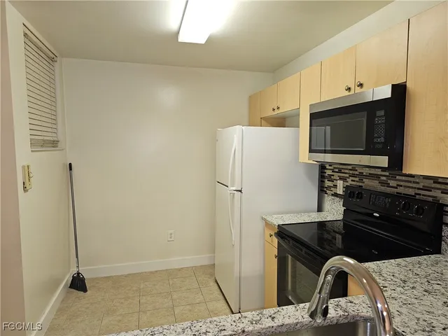 a kitchen with stainless steel appliances granite countertop a refrigerator and a stove top oven