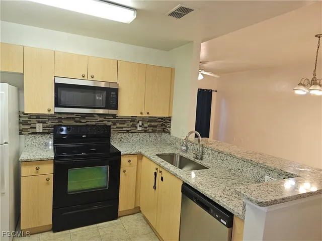 a kitchen with a sink stove and microwave