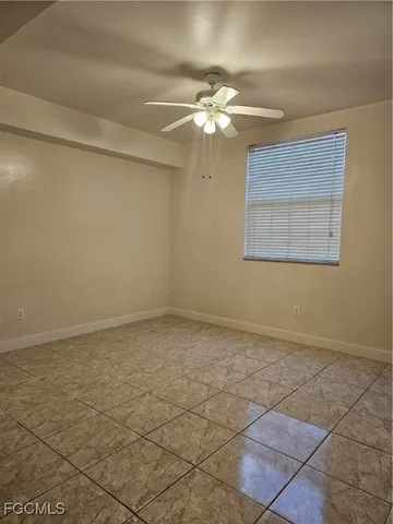 a view of an empty room with a chandelier fan