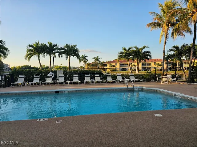 a swimming pool with outdoor seating and a garden