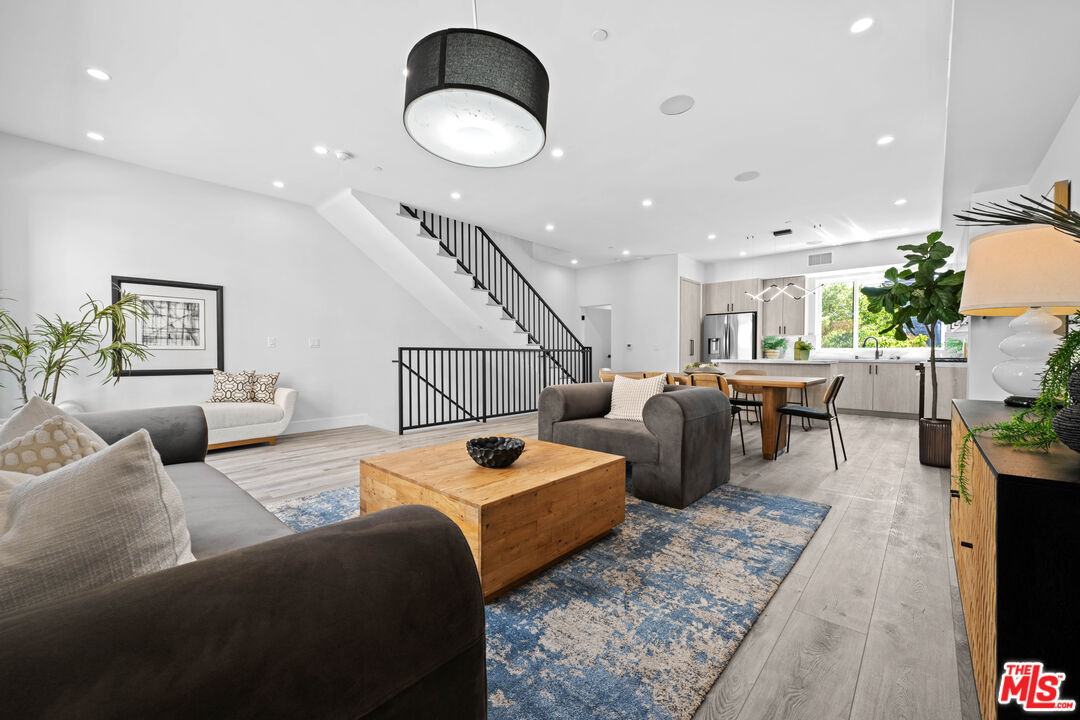 a living room with furniture potted plant and wooden floor