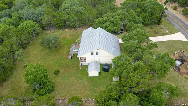 an aerial view of a house with pool garden and trees