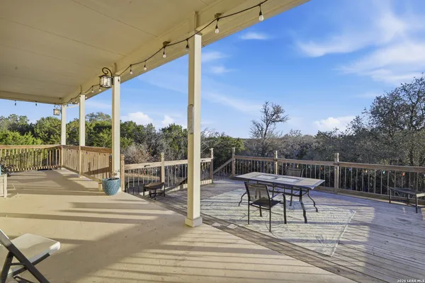 a view of a roof deck with table and chairs with wooden floor and fence
