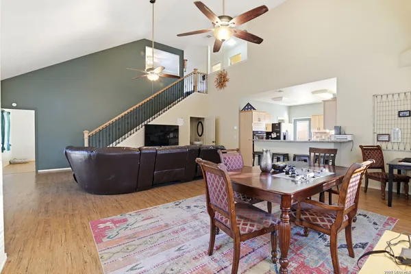 a living room with furniture kitchen view and a chandelier