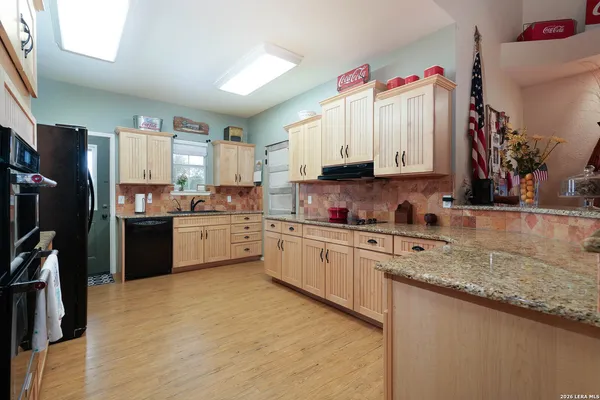 a kitchen with granite countertop a sink stainless steel appliances and cabinets
