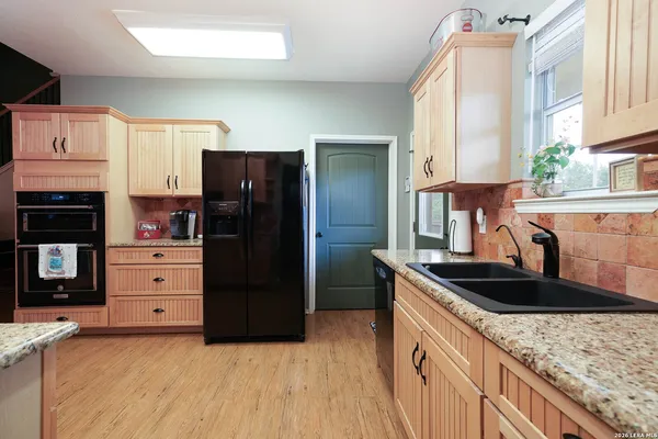a kitchen with granite countertop a refrigerator and a sink